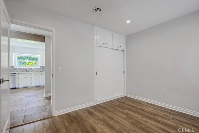 unfurnished bedroom featuring light hardwood / wood-style flooring and a closet