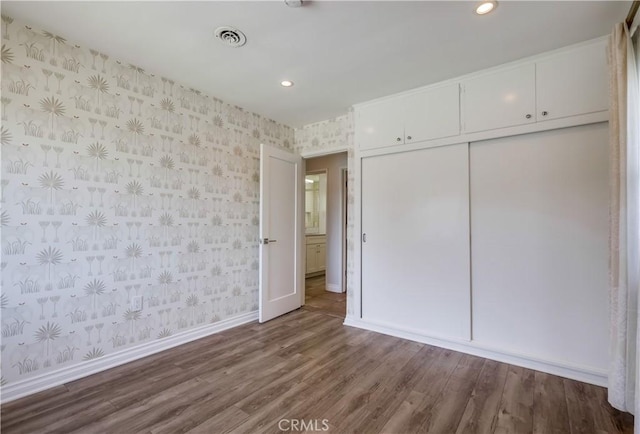 unfurnished bedroom with hardwood / wood-style floors and a closet