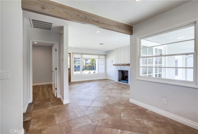 unfurnished living room with tile patterned floors, beamed ceiling, and a fireplace