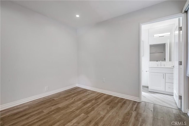 unfurnished room with sink and light hardwood / wood-style floors