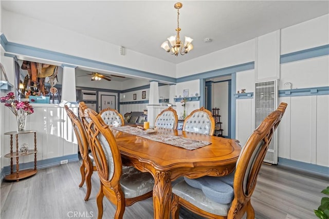 dining space featuring ceiling fan with notable chandelier and light wood-style flooring