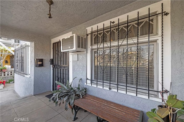 doorway to property featuring a wall mounted AC and stucco siding