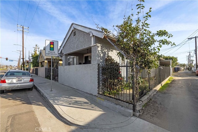 view of home's exterior with fence and stucco siding