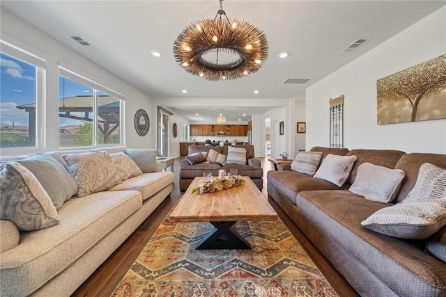 living room with a notable chandelier and dark hardwood / wood-style floors