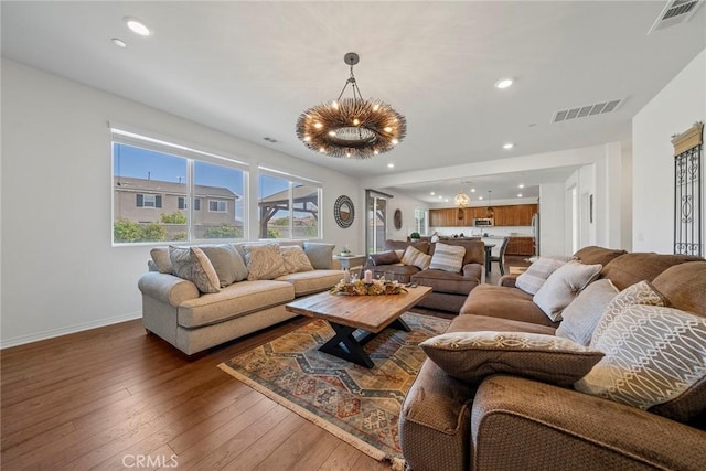 living room featuring an inviting chandelier and wood-type flooring