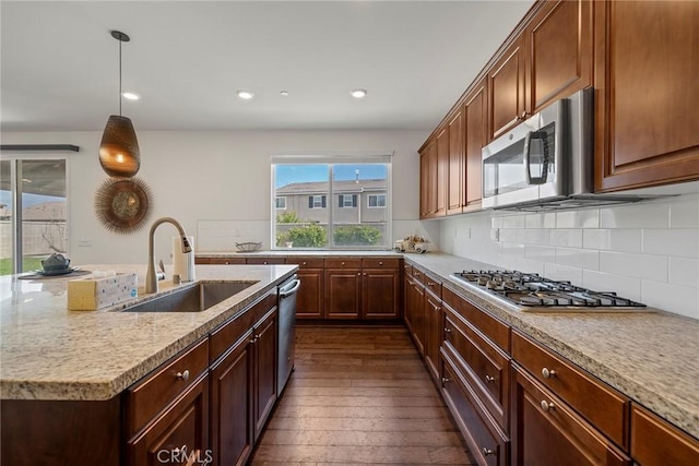 kitchen featuring decorative light fixtures, sink, stainless steel appliances, and light stone countertops