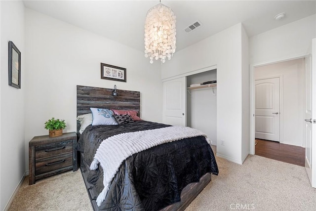 carpeted bedroom featuring a chandelier and a closet