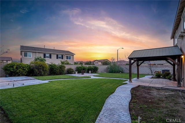 yard at dusk featuring a patio area and a gazebo