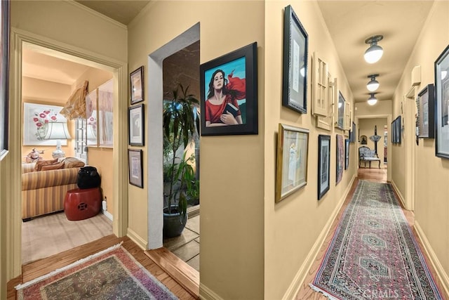 hallway with light wood-style flooring and baseboards