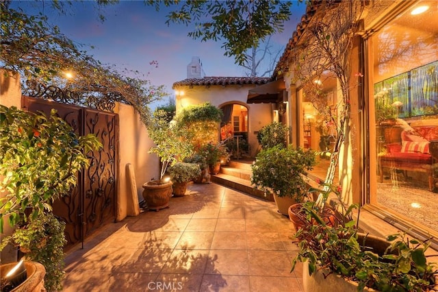 patio terrace at dusk featuring fence