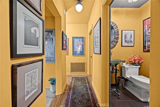 hall with wood finish floors and visible vents