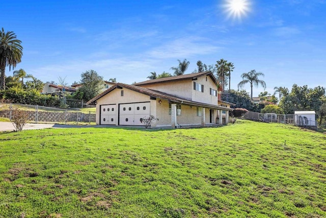 view of side of home featuring a garage, stucco siding, fence, and a lawn