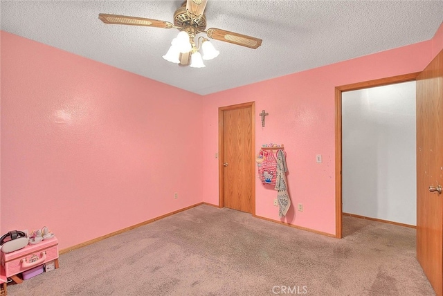 carpeted empty room with a textured ceiling and ceiling fan