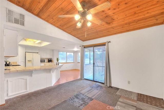 kitchen with tile counters, white appliances, white cabinets, and wood ceiling