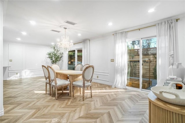 dining room with light parquet flooring, a chandelier, and a healthy amount of sunlight