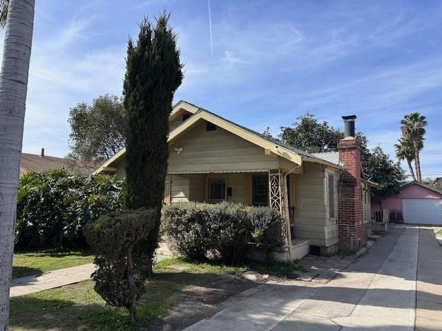 view of front of home with a garage, an outdoor structure, and a chimney