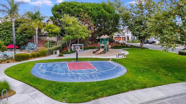 view of basketball court featuring a lawn, community basketball court, and playground community