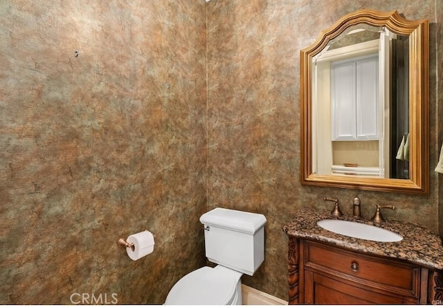 half bathroom with vanity and toilet