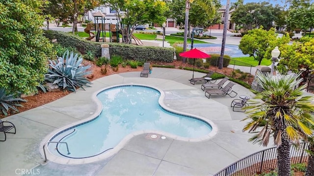 pool featuring a patio, fence, and playground community