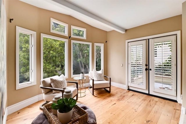 sunroom / solarium with a healthy amount of sunlight, beamed ceiling, and french doors