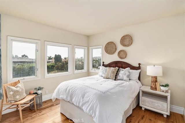 bedroom with baseboards and wood finished floors