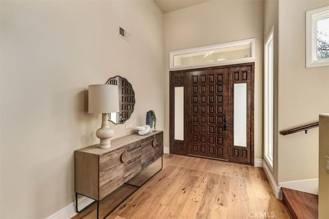 entryway with visible vents, baseboards, and wood finished floors