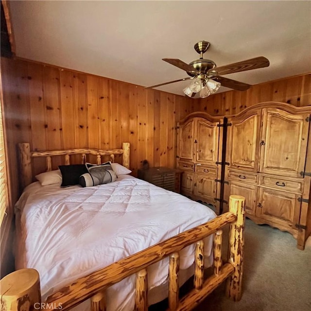 carpeted bedroom with ceiling fan and wooden walls