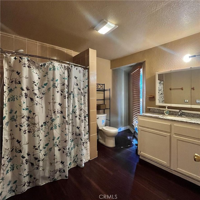 full bathroom with a textured wall, a textured ceiling, toilet, and wood finished floors