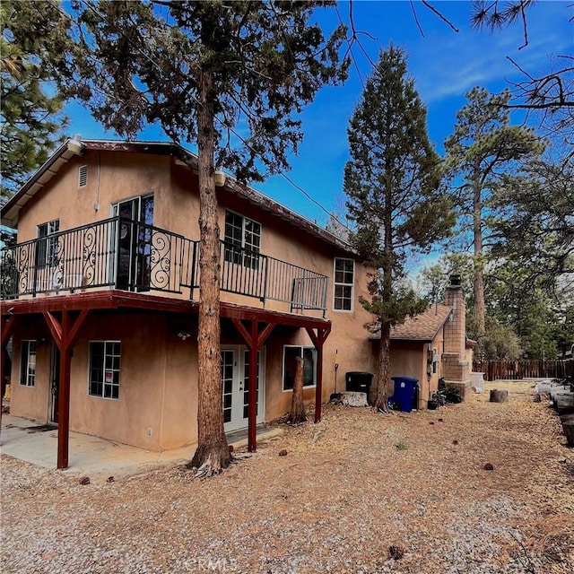 back of property featuring a patio area and stucco siding