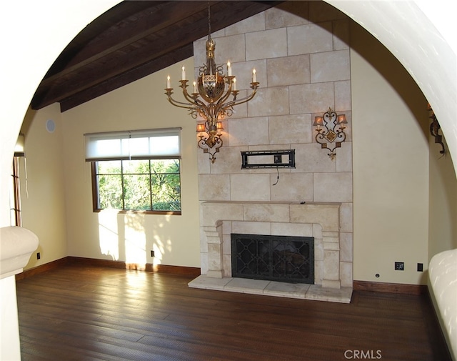 unfurnished living room with a fireplace, dark wood-type flooring, vaulted ceiling with beams, and a chandelier