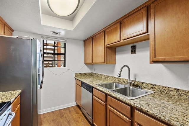 12059 Alta Carmel Ct Unit 167, San Diego, CA 92128 - kitchen featuring a sink, appliances with stainless steel finishes, baseboards, light wood-style floors, and brown cabinets