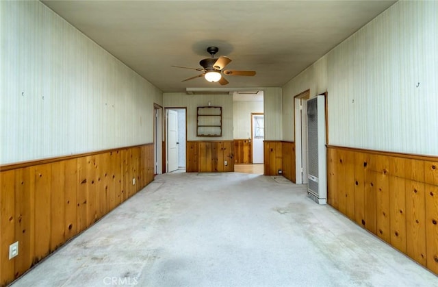 carpeted spare room featuring ceiling fan and wooden walls