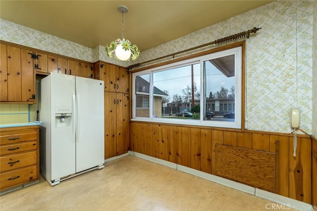 kitchen featuring white refrigerator with ice dispenser and pendant lighting