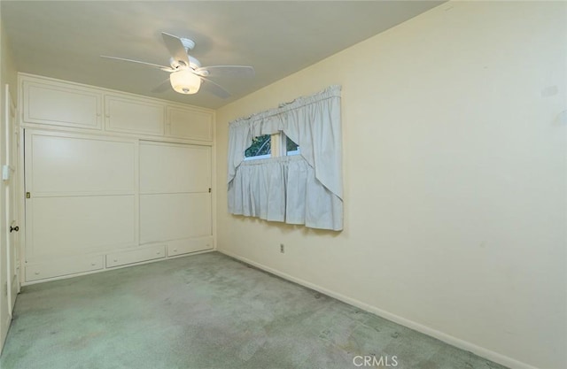 unfurnished bedroom featuring a closet, light colored carpet, and ceiling fan