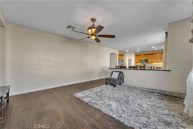 unfurnished living room with ceiling fan and dark hardwood / wood-style floors