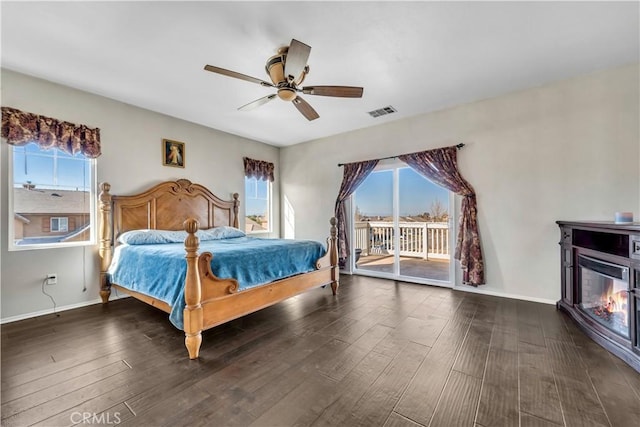 bedroom featuring multiple windows, ceiling fan, access to outside, and dark hardwood / wood-style flooring