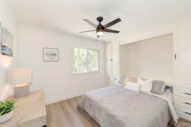 bedroom with light wood-style floors, baseboards, and a ceiling fan