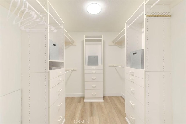 walk in closet with wood finished floors