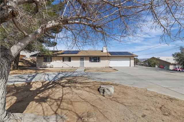 ranch-style home featuring solar panels and a garage