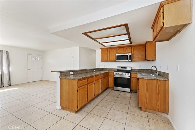 kitchen with sink, kitchen peninsula, appliances with stainless steel finishes, and light tile patterned flooring