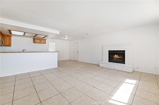 unfurnished living room featuring light tile patterned flooring and a fireplace