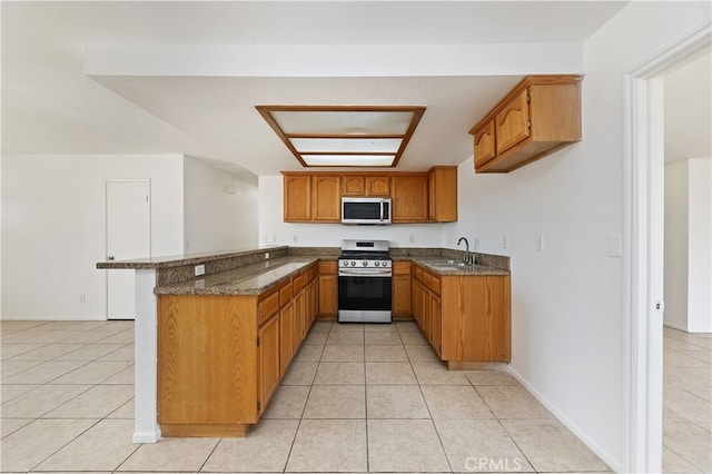 kitchen with light tile patterned flooring, appliances with stainless steel finishes, sink, and kitchen peninsula