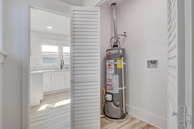 utility room with sink and secured water heater