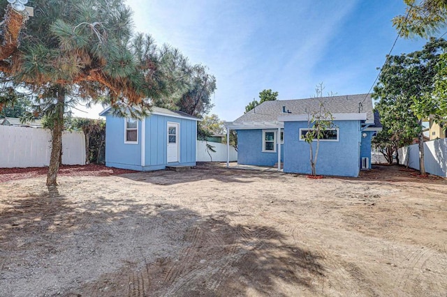 rear view of property with a storage unit