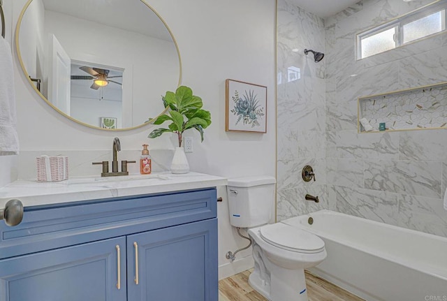 full bathroom featuring toilet, tiled shower / bath, ceiling fan, wood-type flooring, and vanity