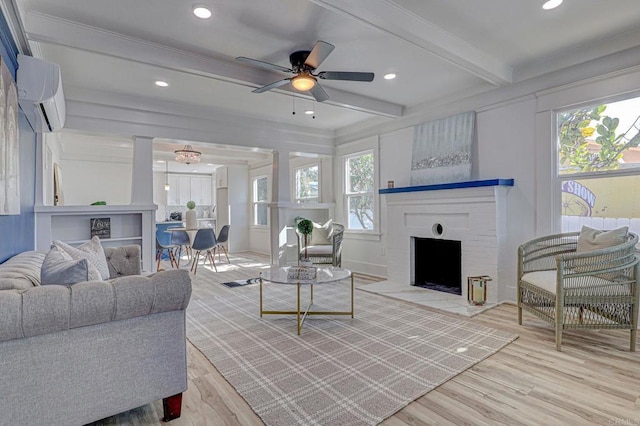 living room with ceiling fan, beamed ceiling, light wood-type flooring, and a wall mounted air conditioner