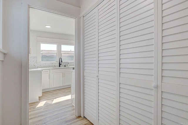 corridor featuring light hardwood / wood-style flooring and sink