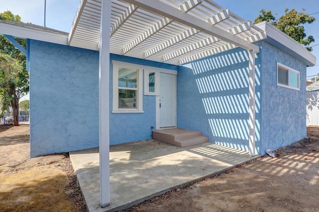 property entrance with a pergola