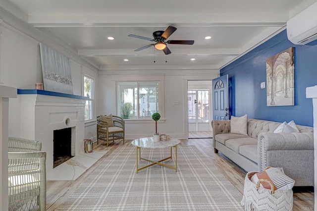 living room with an AC wall unit, a wealth of natural light, beamed ceiling, and hardwood / wood-style floors