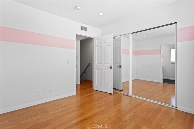 unfurnished bedroom featuring baseboards, visible vents, light wood-style floors, a closet, and recessed lighting